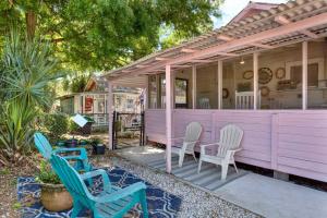 a pink house with two chairs and a table at Rocca Cottages in Tybee Island
