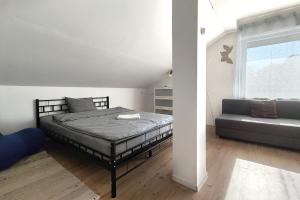 a bedroom with a bed and a couch at Bandiland Szigetmonostor Horány in Szigetmonostor