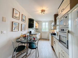una cucina con un piccolo tavolo e sedie di La Fraisnaie Omaha Beach a Saint-Laurent-sur-Mer