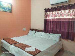 un letto in una stanza con una finestra con un cartello sopra di Saurabh Guest House, Akkalkot a Akalkot