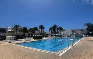 una grande piscina con palme e edifici di Oasis Costa del Silencio a Costa Del Silencio