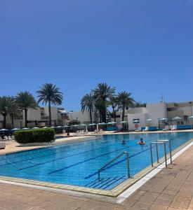 una piscina con palme e persone di Oasis Costa del Silencio a Costa Del Silencio Altre 16 foto