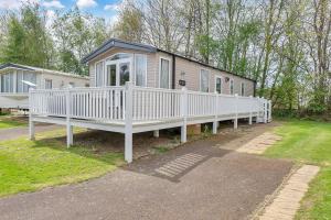 a mobile home with a white porch and a house at Vacant Nests Seton Sands The Wentworth Wifi in Port Seton