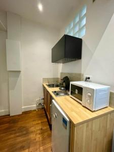 una cocina con encimera y microondas en Studio Auteuil Suchet Paris, en París 11 fotos más