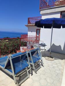 a patio with a table and chairs and an umbrella at Hotel Dania in Sorrento