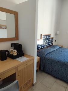 a bedroom with a bed and a desk and a mirror at Hotel Dania in Sorrento