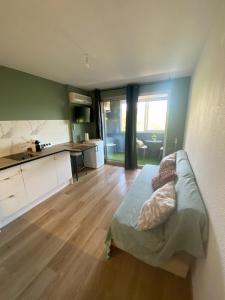 a living room with a bed and a kitchen at Le Zen studio rénové in Balaruc-les-Bains +19 photos