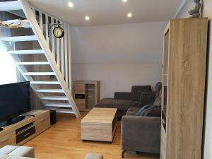 a living room with a couch and a staircase at Olivia in Sianozety