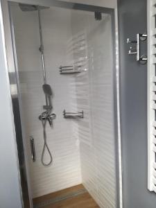 a shower in a bathroom with a white wall at Olivia in Sianozety