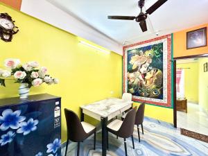a dining room with a table and a painting on the wall at Colorful 3BHK Apartment Near Eco Park, Newtown Kolkata in kolkata