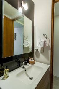 bagno con lavandino e grande specchio di The City Condos by Menesse a Playa del Carmen