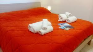 Una cama con cuatro toallas enrolladas. en Bilocale Delle Robinie in Baia Verde, en Baia Verde