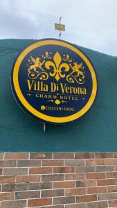 a sign for a villa del veneto chain hotel at Villa Di Verona Charm Hotel in Guarujá