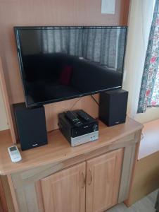 TV de pantalla plana grande en la parte superior de un armario de madera en Casa da Cristina 5A, en Burinhosa