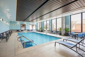 a pool with chairs and tables in a building at SpringHill Suites Madison in Madison