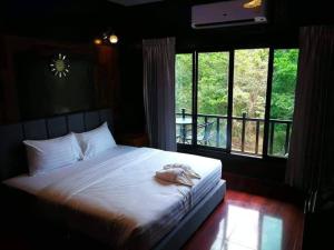 a bedroom with a bed with towels on it at นาธาริเวอร์ไซด์ in Ban Lamphu La (3)