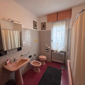 a bathroom with a sink and a toilet and a window at Casa Claudia in Riva di Solto