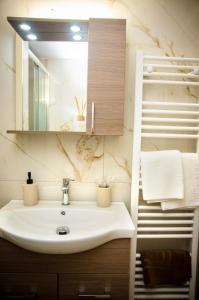 a bathroom with a sink and a mirror and towels at M & E Guesthouse in Volos +37 photos