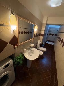 a bathroom with two sinks and a washing machine at Sofia's modern apartment in Gjirokastër