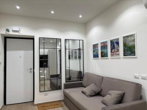 a living room with a couch and some pictures on the wall at Bella Como Holiday Apartment in Como
