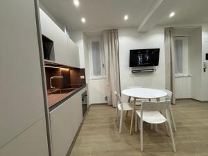a kitchen with a white table and chairs in a room at Bella Como Holiday Apartment in Como