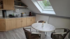 a kitchen with a table and chairs and a window at Ferienwohnung Wolkennah in Sohren