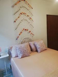 a bedroom with a white bed with pink pillows at Chiltern cottages in Amphoe Koh Samui