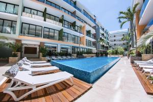 un hotel con piscina e sedie a sdraio di The City Condos by Menesse a Playa del Carmen