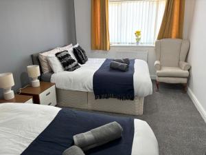 a hotel room with two beds and a chair at Sunderland City Delight free parking in Sunderland