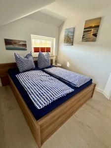 a bedroom with a bed with blue and white pillows at Schlösschen am Schmachter See in Binz