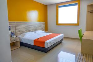 マンサニージョにあるHotel Motel Nivel 10のベッドルーム1室(オレンジ色の壁のベッド1台付) +3枚の写真