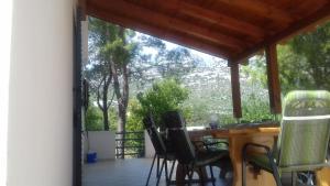 a porch with chairs and a table on a deck at Kuća Mare, 130m od mora in Seline