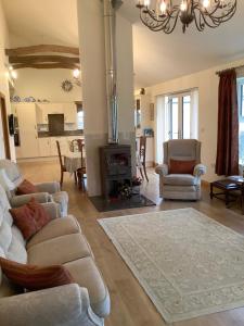 Elle comprend un salon doté d'un mobilier blanc et d'une cheminée. dans l'établissement Orchard Cottage, Clematis cottages, Stamford. Accessible luxury home., à Stamford