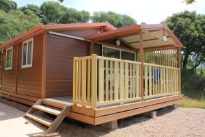 a wooden cabin with a porch and a staircase at Les Hauts de Torraccia in Cargèse +2 photos
