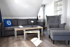 a living room with a couch and a chair and a table at Fewo In dat Huus in Grube