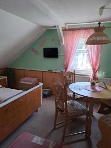 une chambre avec un lit, une table et une télévision dans l'établissement Pension Kaufmann Ferienwohnung 2, à Oberwiesenthal