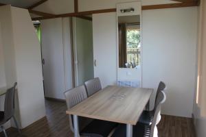 a dining room with a wooden table and chairs at Les Hauts de Torraccia in Cargèse