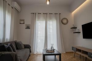 a living room with a couch and a clock on the wall at Lemon Nest in Athens
