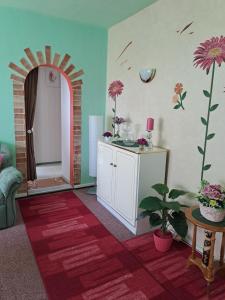 a room with a table and a room with flowers on the wall at Pension Kaufmann Ferienwohnung "Wolke 7" in Oberwiesenthal