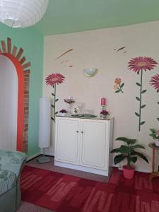 a living room with flowers on the wall at Pension Kaufmann Ferienwohnung "Wolke 7" in Oberwiesenthal +30 photos