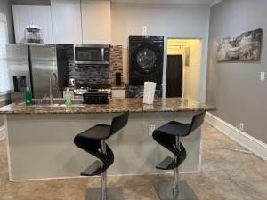 a kitchen with a counter with two black stools at Nice & Cozy 3 bedroom Escape in Waycross +26 photos