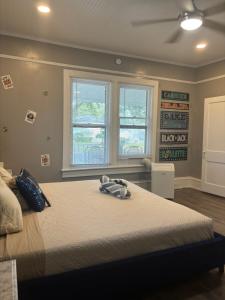 a bedroom with a large bed and two windows at Nice & Cozy 3 bedroom Escape in Waycross