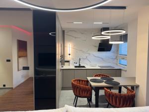 帕尔杜比采Moderní Hi-Tech apartmán v centru Pardubic - Wi-Fi, Netflix, projektor的配有桌椅的厨房和餐厅