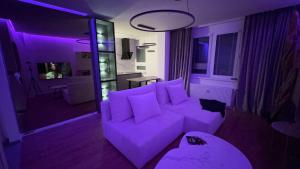 帕尔杜比采Moderní Hi-Tech apartmán v centru Pardubic - Wi-Fi, Netflix, projektor的客厅配有紫色灯光和沙发 更多22张照片