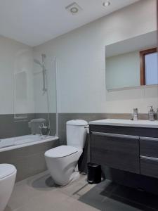 a bathroom with a toilet and a tub and a sink at Costa Suite Beach, Pool and Parking in Lloret de Mar +13 photos