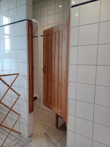 a bathroom with a wooden door and white tiled walls at Rosario in Bever +50 photos
