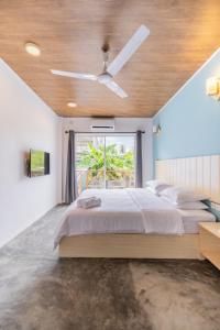 a bedroom with a bed and a ceiling fan at Bibee Surf in Thulusdhoo