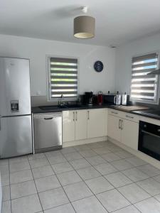 a kitchen with white cabinets and stainless steel appliances at LIL de SAND in Bourcefranc