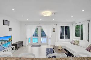 Una sala de estar con un sofá blanco y un televisor. en Central Stunning Villa with Heated Pool Cabana, en Hollywood Ridge Farms
