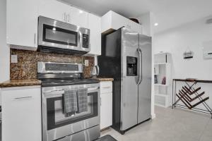 Una cocina con refrigerador de acero inoxidable y microondas. en Central Stunning Villa with Heated Pool Cabana, en Hollywood Ridge Farms 49 fotos más